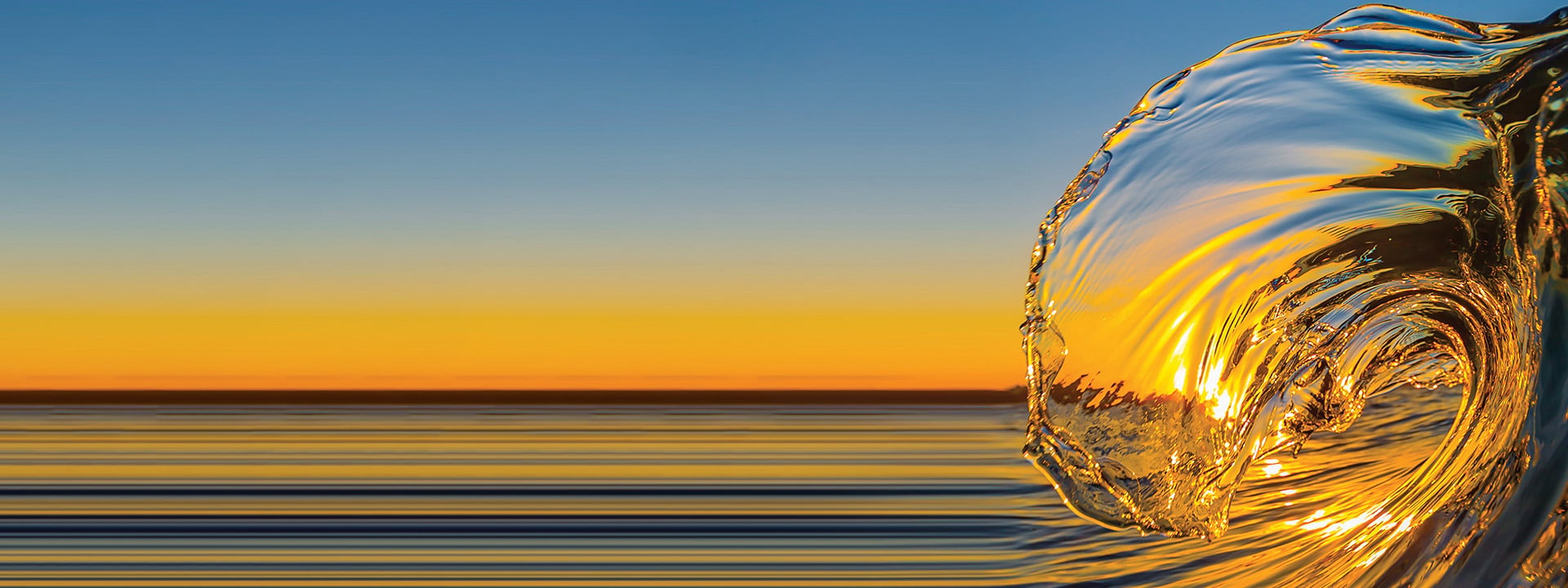 Closeup of a wave with a sunset behind it