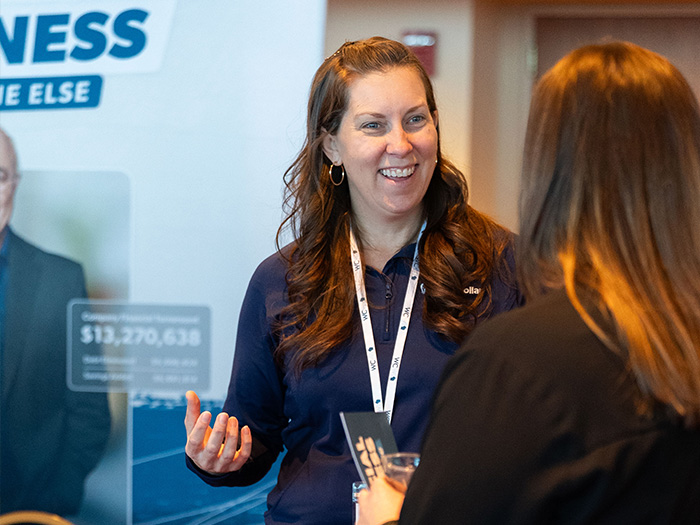 An exhibitor talking to a woman and smiling
