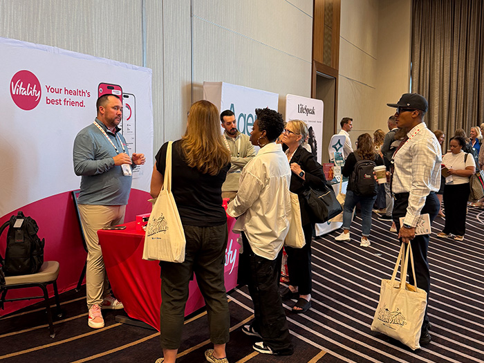 Multiple exhibitors lined up talking to people in an exhibitor space