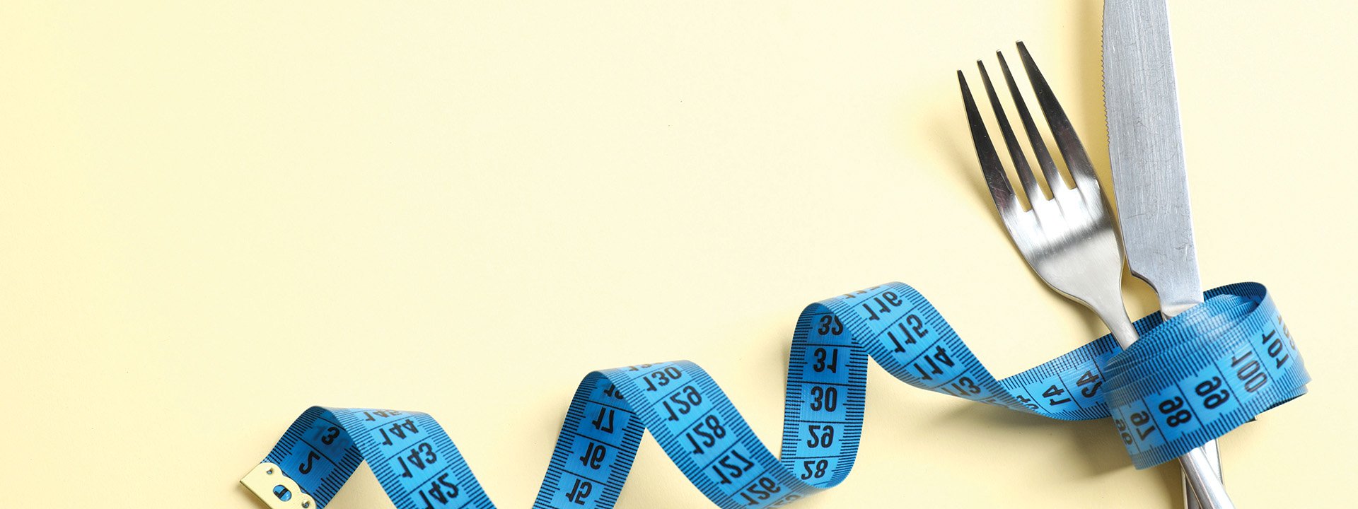 A fork and knife bound together by measuring tape