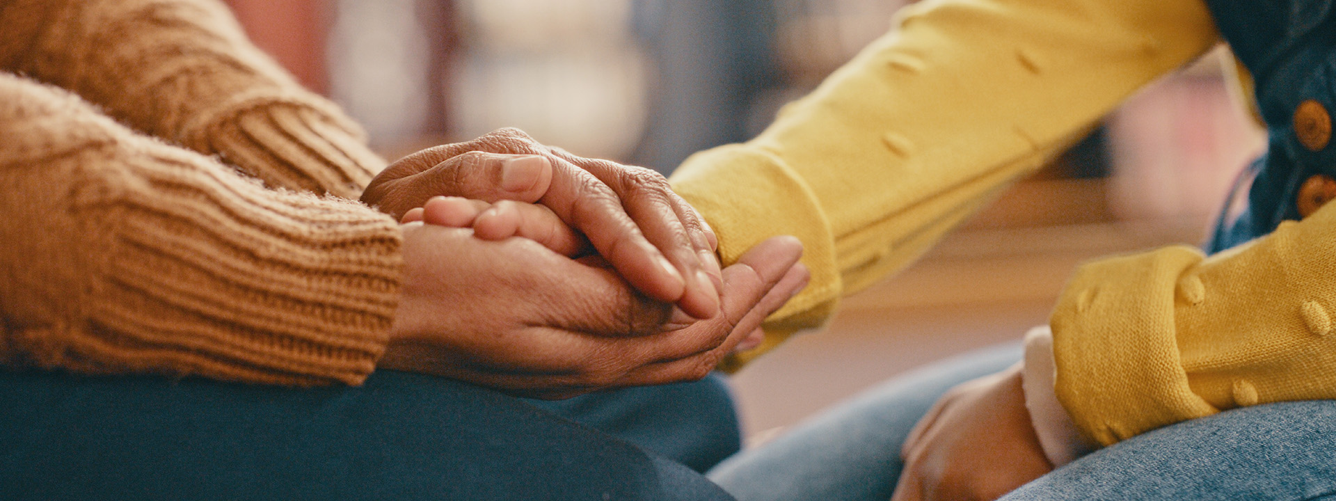 Closeup of someone's hands clasped around someone else's hand