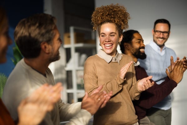 Happy business team applauding during a meeting in the office