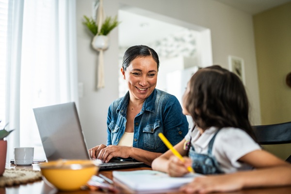 Mother and daughter working together at the kitchen table.
