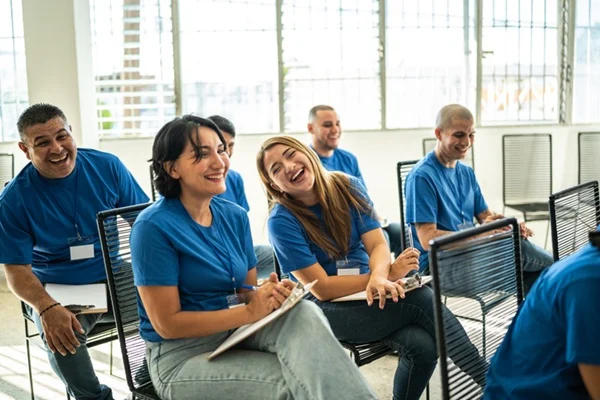 Volunteers paying attention and smiling on a community center presentation