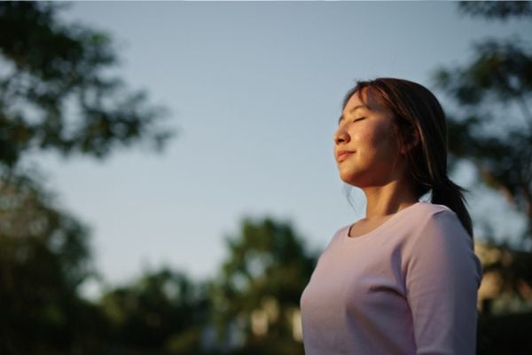 Woman meditating outdoors.