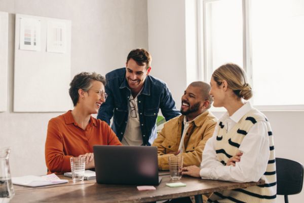 Cheerful designers smiling happily while having a meeting in an office.