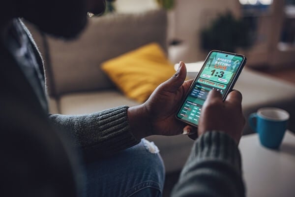 A man placing bets on his mobile device.