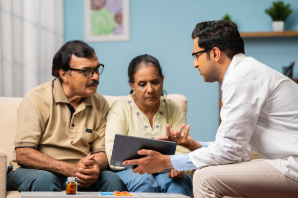 Doctor explaining from digital tablet to senior couple about medical report