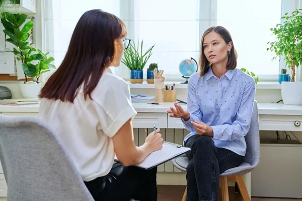 Women discussing mental health concerns in the office.