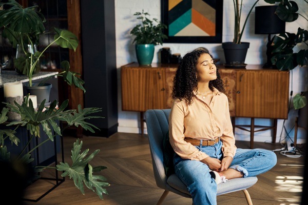 Woman in a lounge chair taking a meditation and mindfulness break, thinking about life, gratitude and self care.