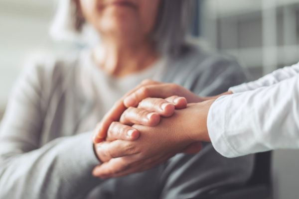 Hands holding old woman's hands