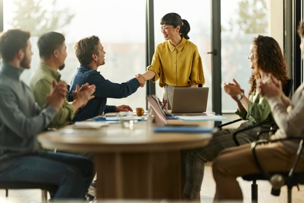 Happy business colleagues shaking hands in a meeting.