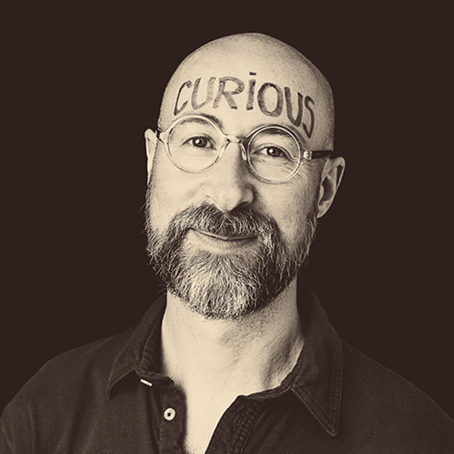 Man with CURIOUS written on his forehead