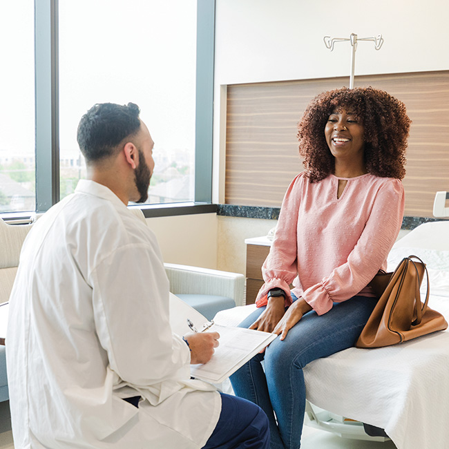 A patient smiling, talking with a doctor