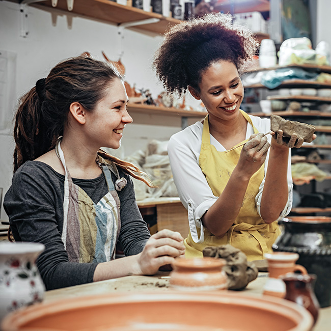 Two women working with pottery