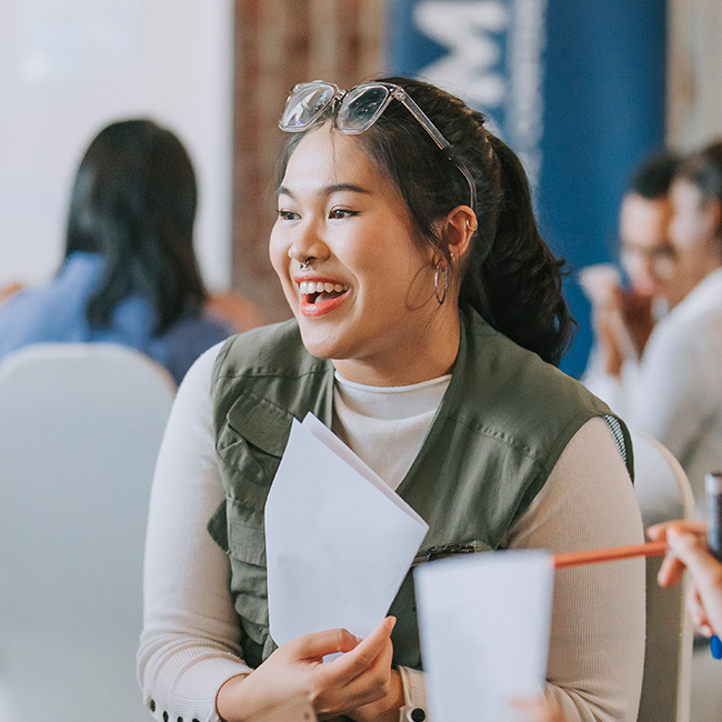 A woman holding a piece of paper, smiling