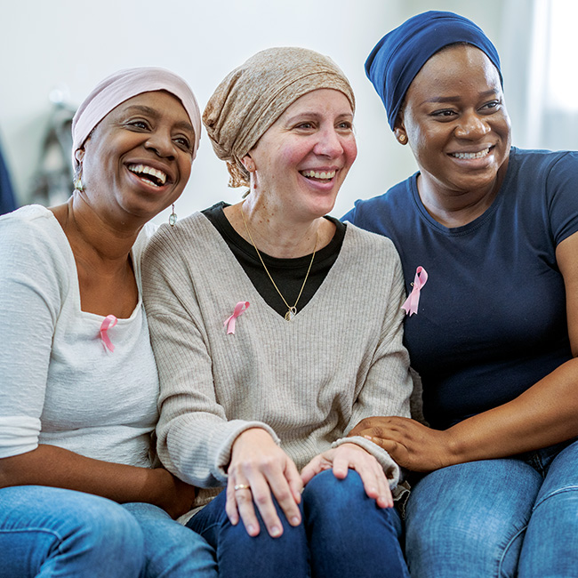 Three women, possibly cancer patients, sitting together and smiling