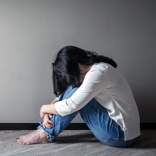 A person sitting on the floor with head down
