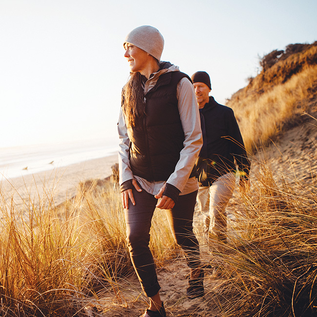 A woman and a man on a hike, following a trail