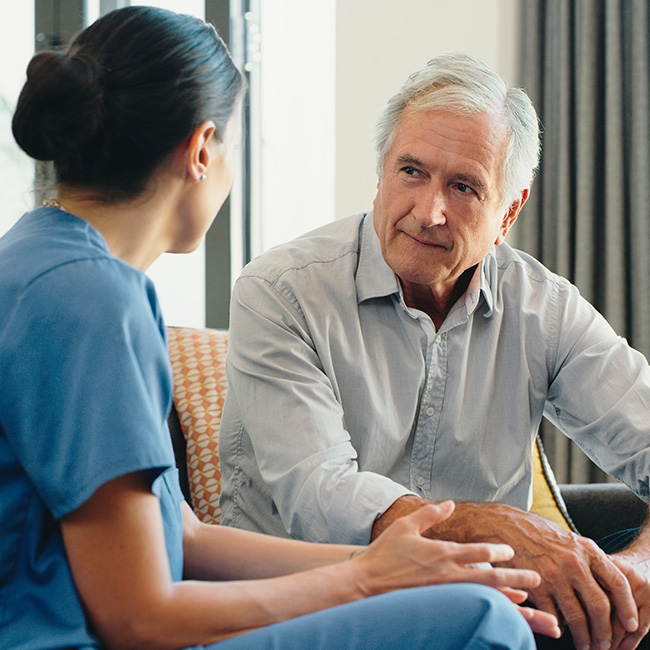 An older man speaking with a health professional
