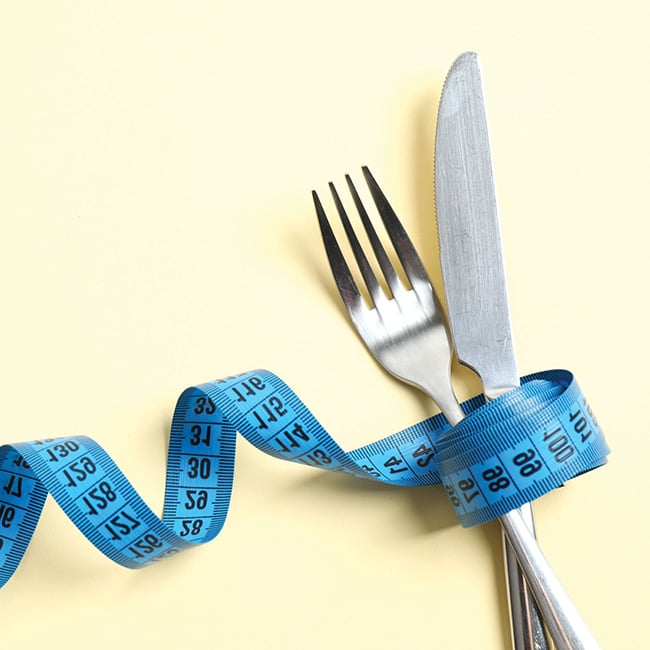 A fork and knife bound together by measuring tape